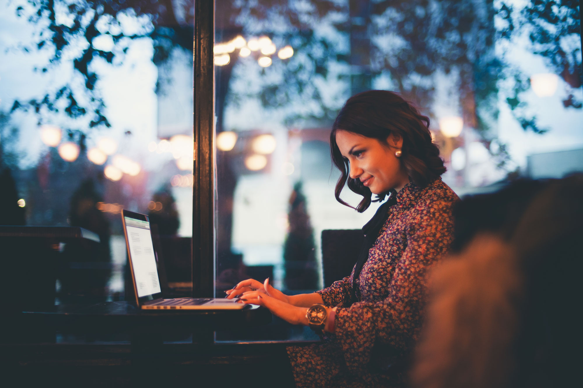 middle age woman sitting in cafe on laptop computer
